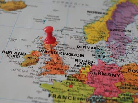 Close-up of a European map highlighting the UK with a red pin, perfect for geography themes.